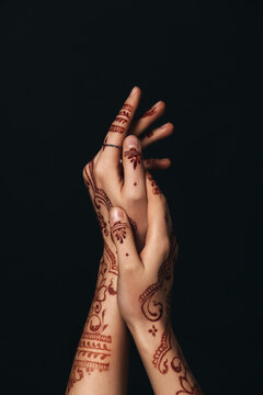 Beautiful henna designs on hands against dark background