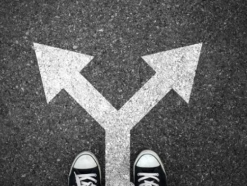 Feet at a crossroads with arrows